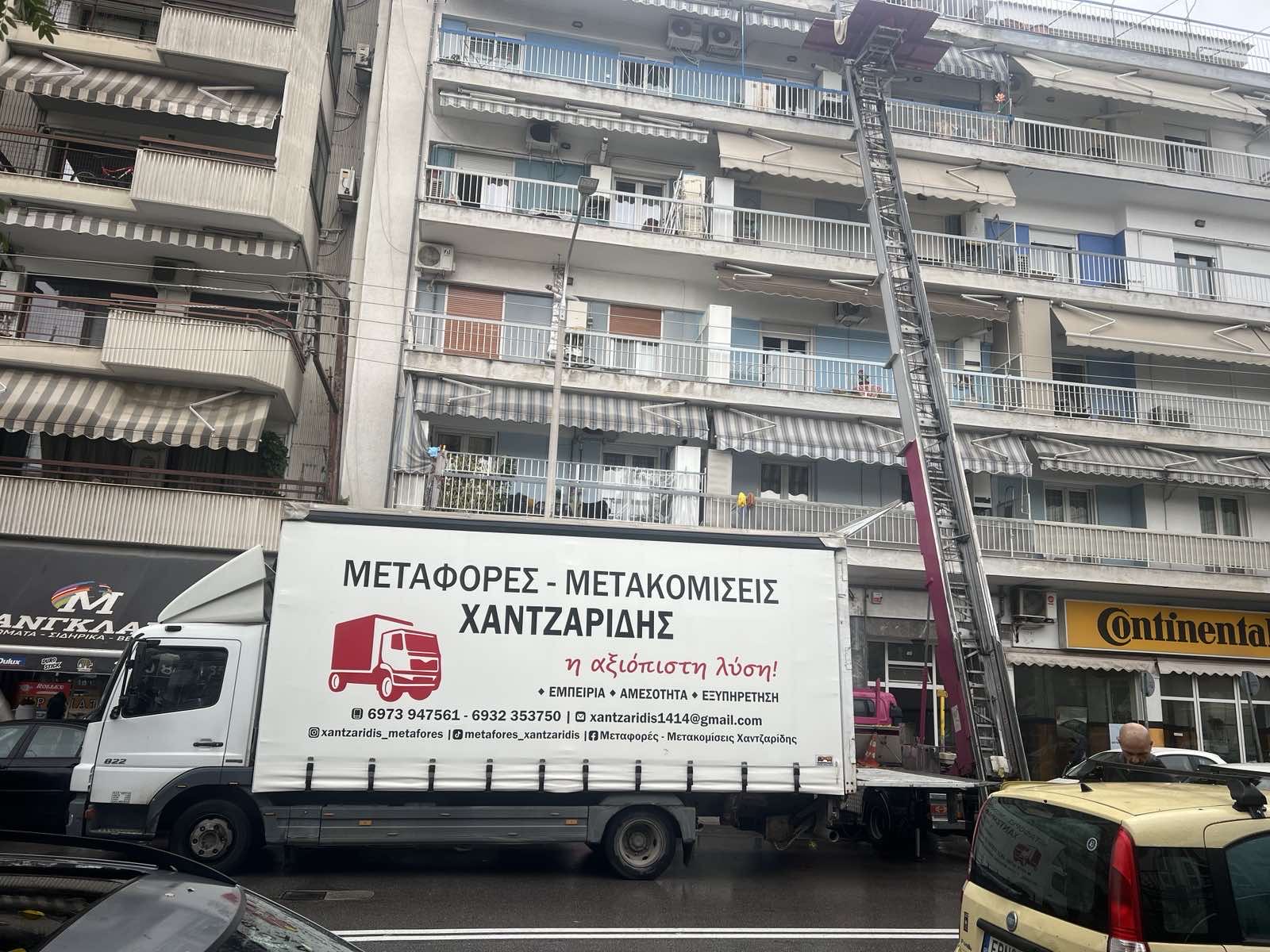 Φορτηγό μετακομίσεων Χαντζαρίδης σε κεντρικό δρόμο Θεσσαλονίκης με ανυψωτικό